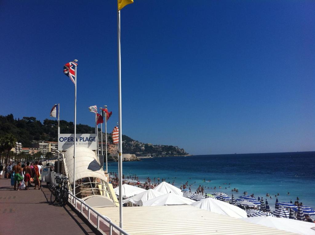 plaża z grupą ludzi i ocean w obiekcie Hotel Cresp w Nicei