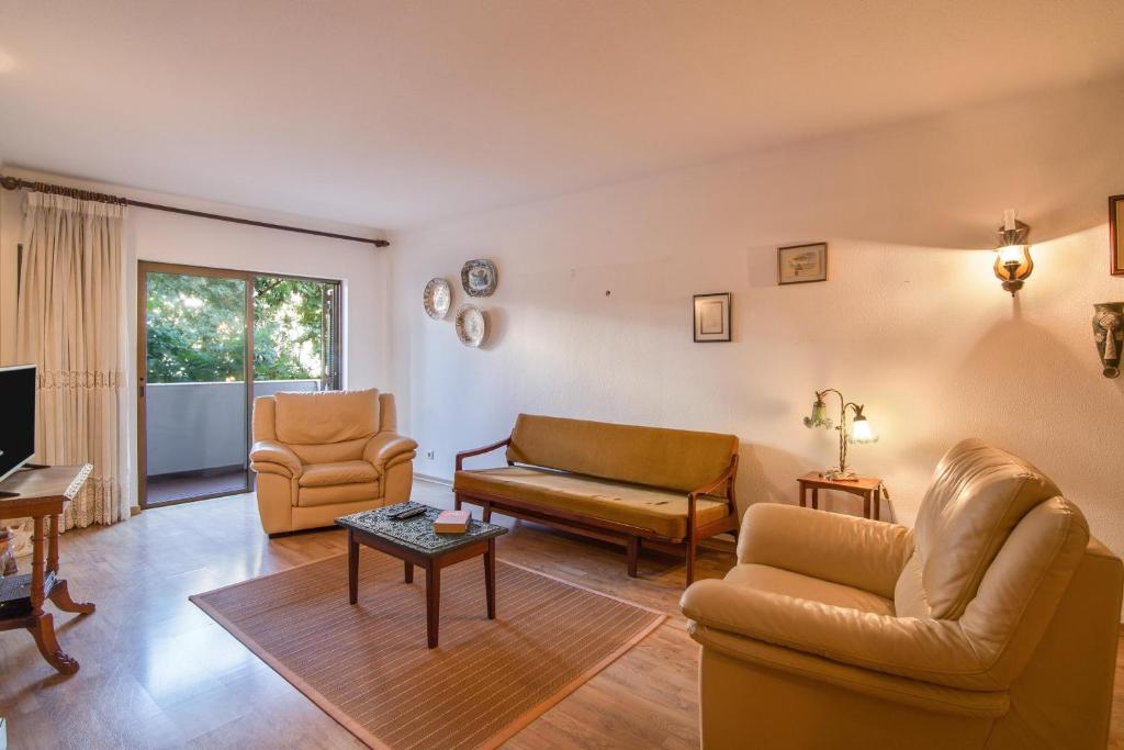 salon z 2 krzesłami i kanapą w obiekcie Apartamento Avenida da Liberdade w Albufeirze