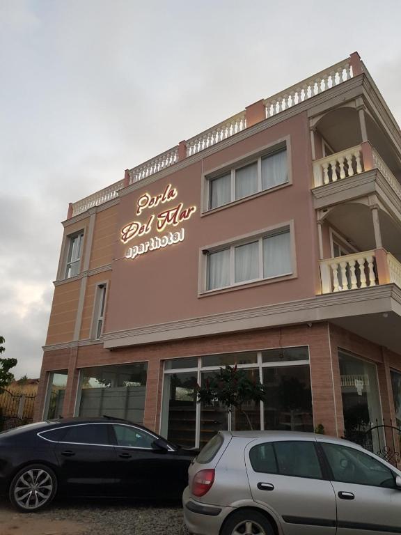two cars parked in front of a building at Perla Del Mar Aparthotel in Lozenets