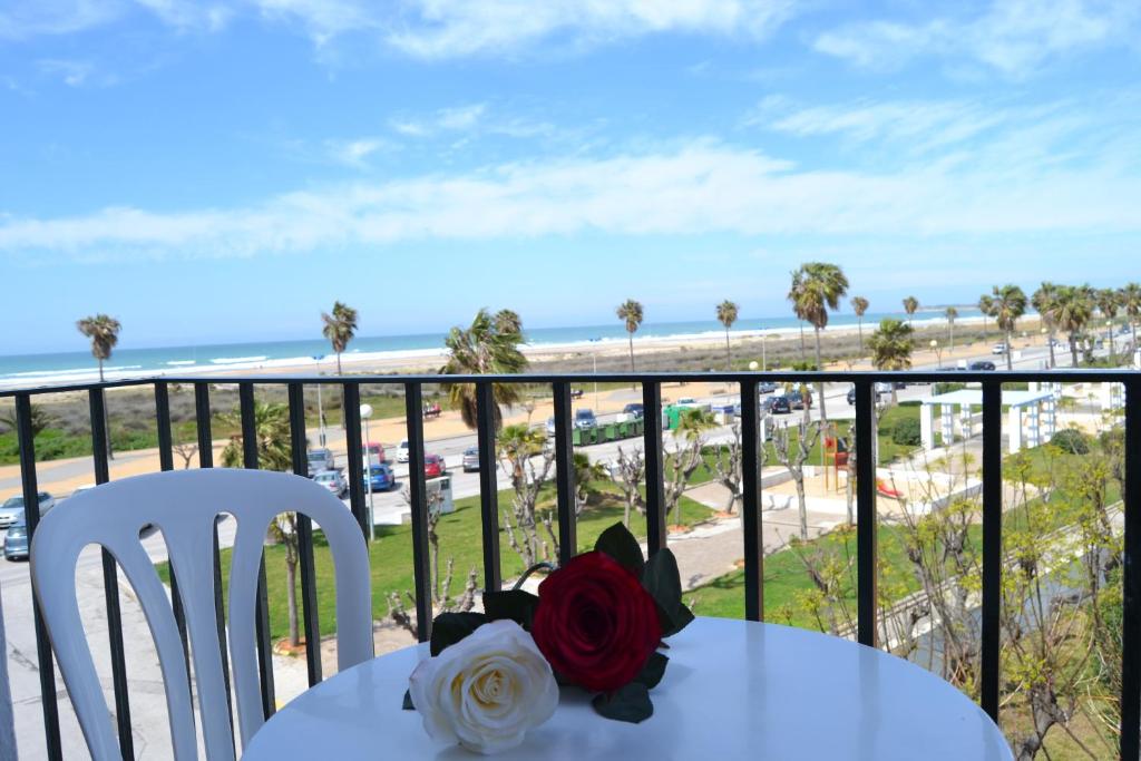 a table and chairs with a view of the beach at Hotel Oasis in Conil de la Frontera