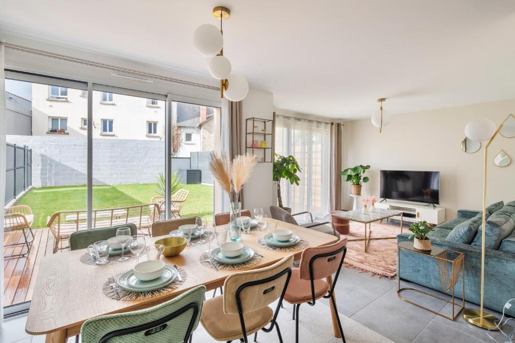 uma sala de jantar com mesa e cadeiras e uma sala de estar em Maison Twin Sister em Rennes