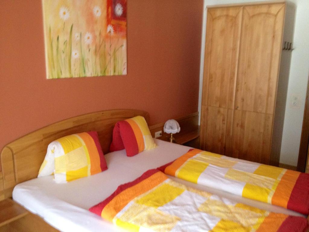 a bedroom with a bed with colorful pillows at Ferienwohnungen Pernull in Waidegg