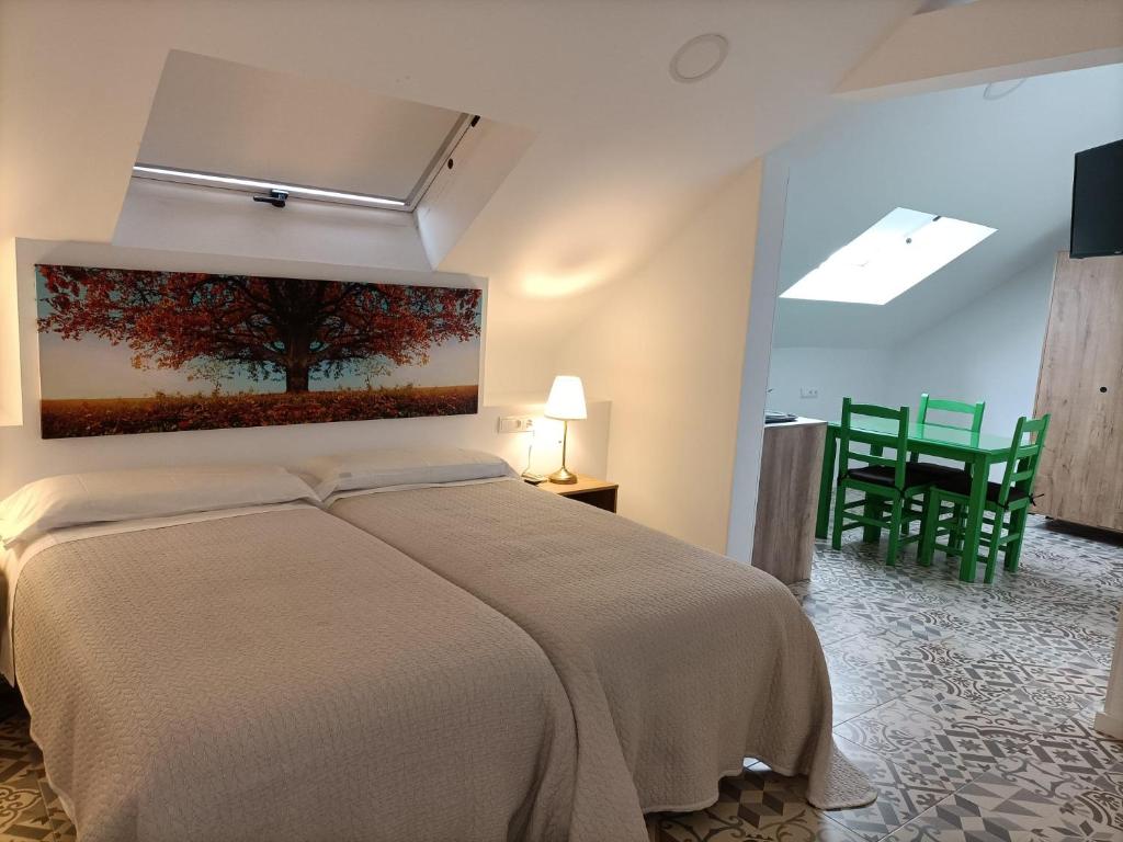 um quarto com uma cama com um quadro na parede em Hostal Las Encinas em Villaviciosa de Odón