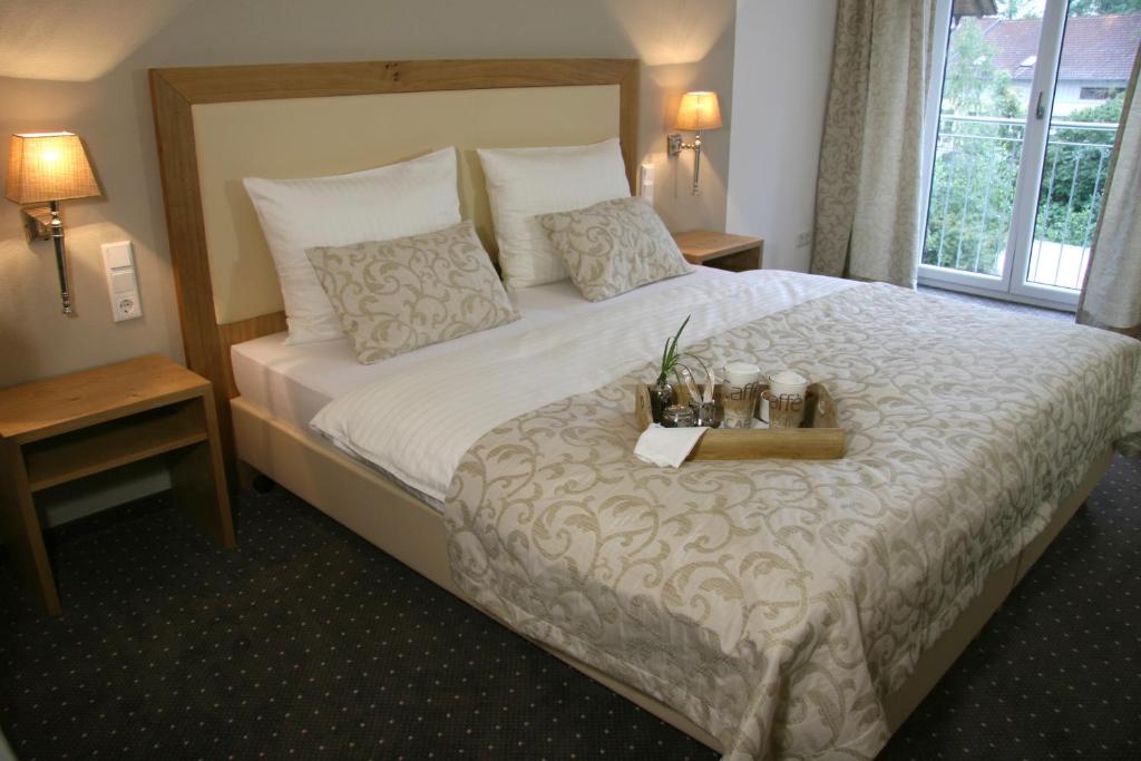 a hotel room with a bed with a tray on it at Gästehaus an der Sempt - Wohlfühlen auf dem Lande in Erding