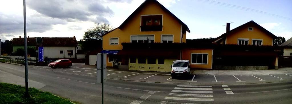 Našice的住宿－restoran i prenoćište Egghus，停在黄色房子前面的白色汽车