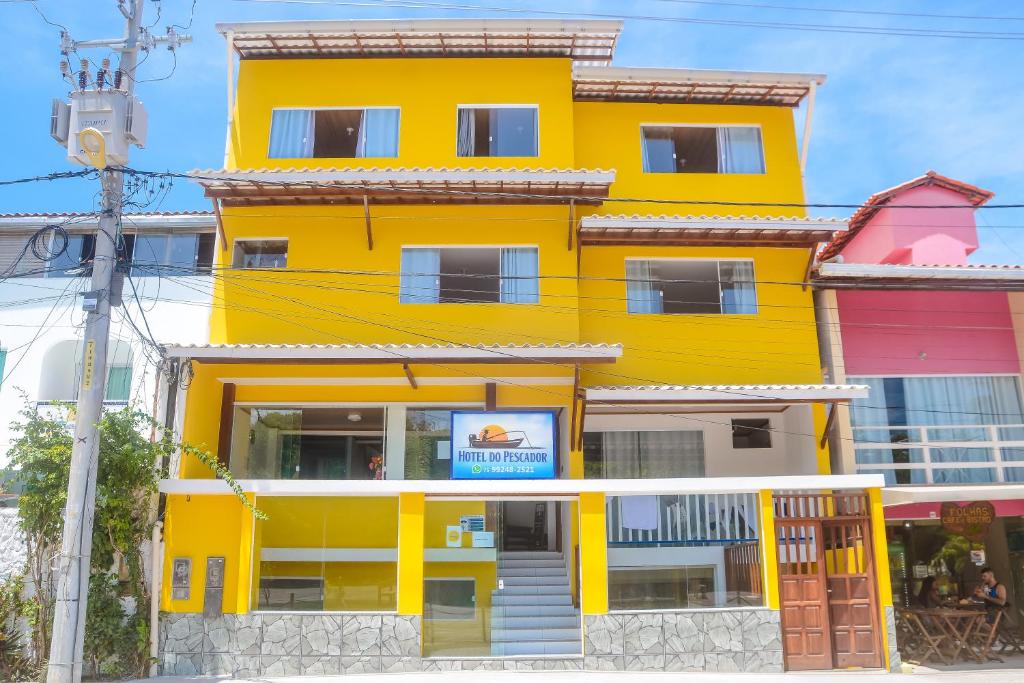 un bâtiment jaune avec un panneau sur lequel figure un panneau dans l'établissement Hotel do Pescador, à Morro de São Paulo