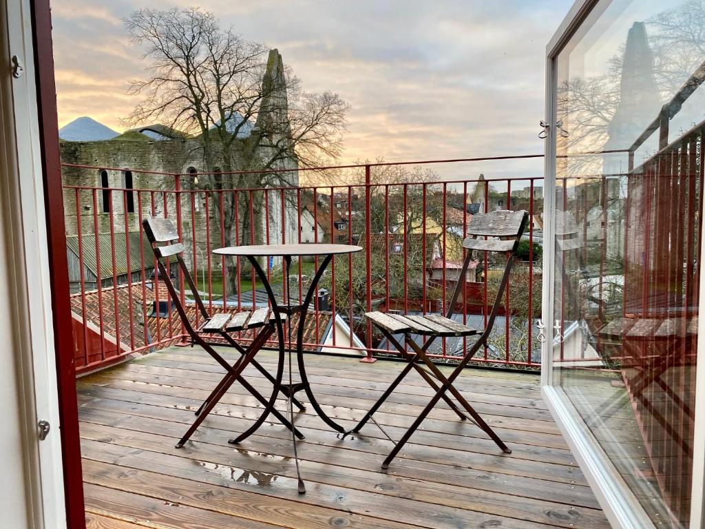 Un balcón con 2 sillas y una mesa en una terraza. en Sköna Hönor Apartments en Visby