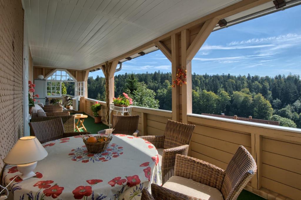 a screened in porch with a table and chairs at Landhaus-Apartment Feldbergblick in Sankt Märgen