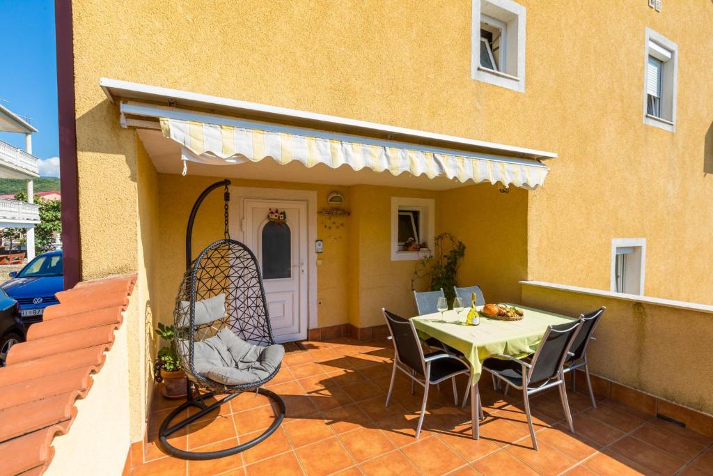 a patio with a table and chairs next to a building at DIANA in Crikvenica