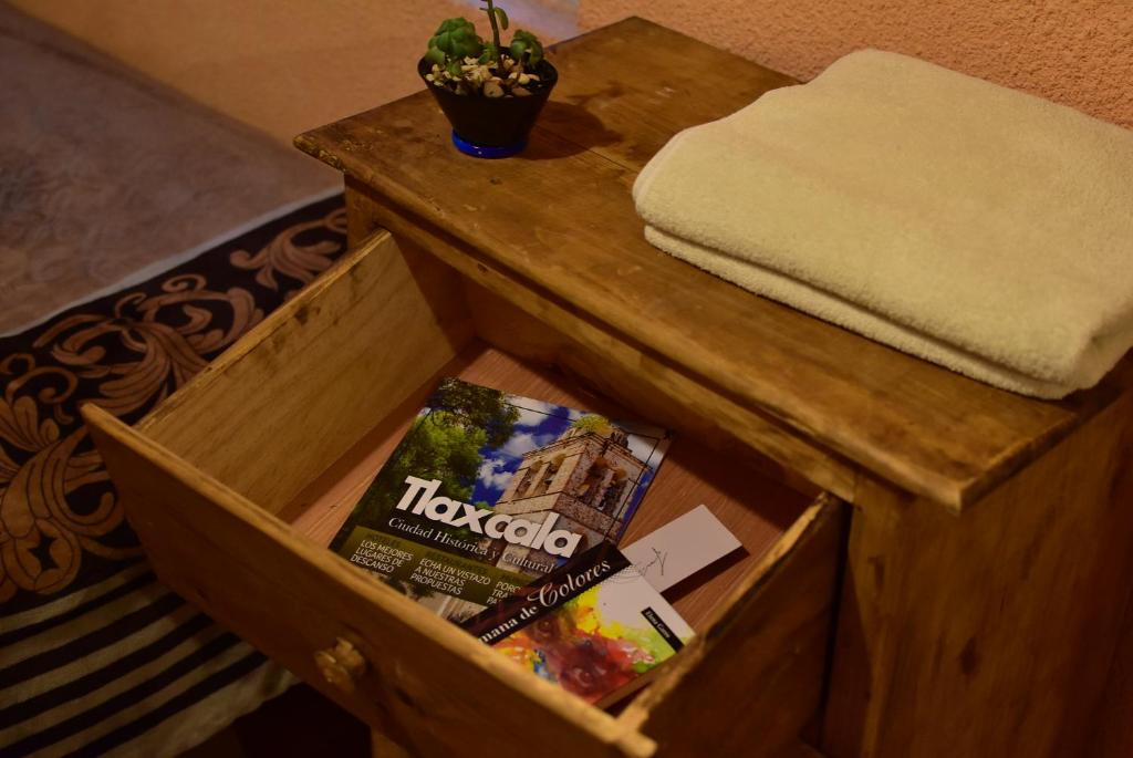 a wooden box with a magazine on top of a table at Hostal Quinto Sol Huamantla in Huamantla