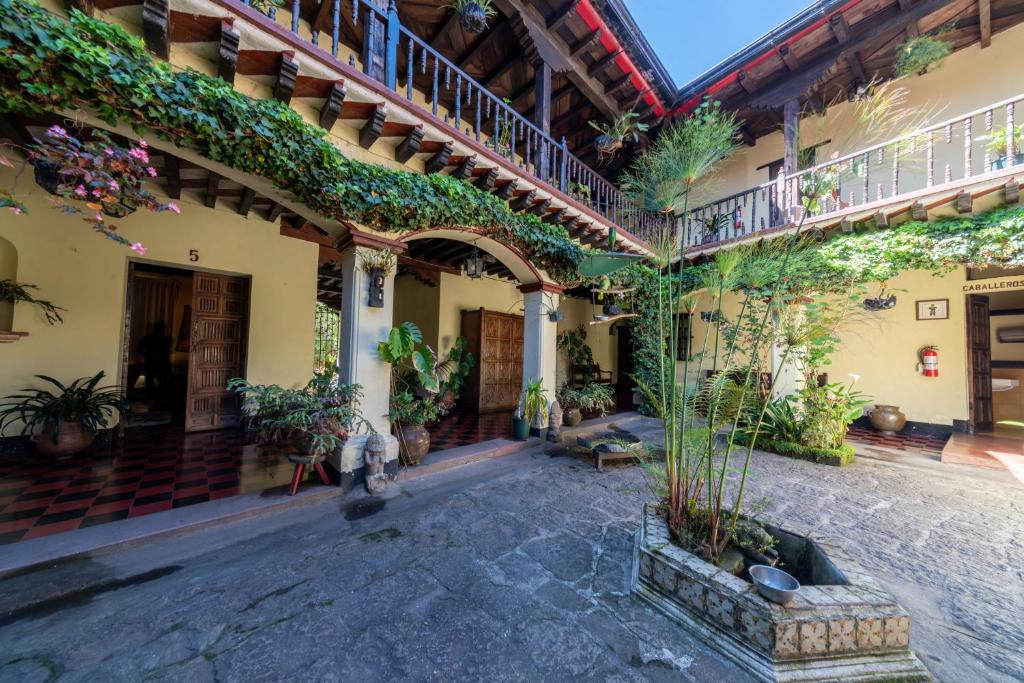 een binnenplaats van een oud gebouw met planten bij Hotel Museo Mayan Inn in Chichicastenango