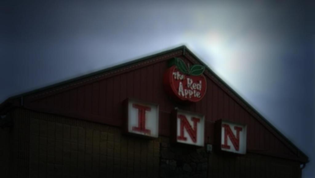 un panneau sur le côté d'un bâtiment avec une pomme sur celui-ci dans l'établissement Red Apple Inn, à Wayne