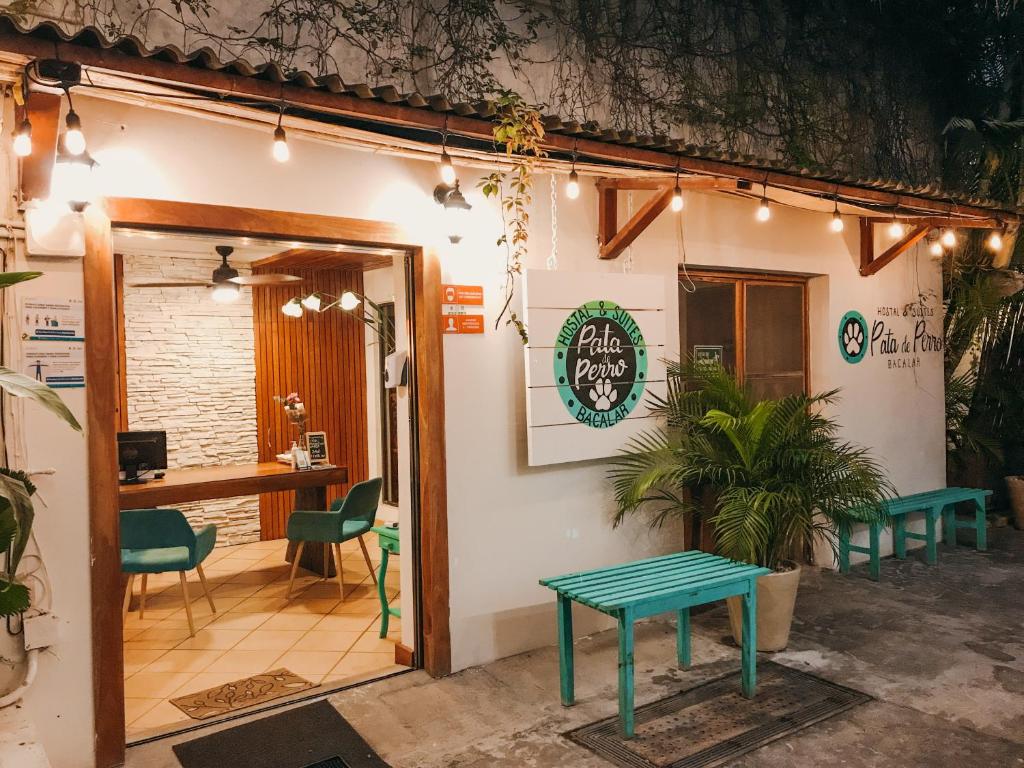 a coffee shop with a green bench in front of it at Hostal & Suites Pata de Perro in Bacalar