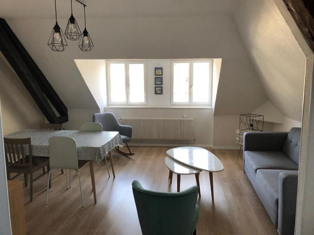 un soggiorno con tavolo e divano di Chez Jules ,Parking gratuit, 3ème Etage a Saint-Valéry-sur-Somme