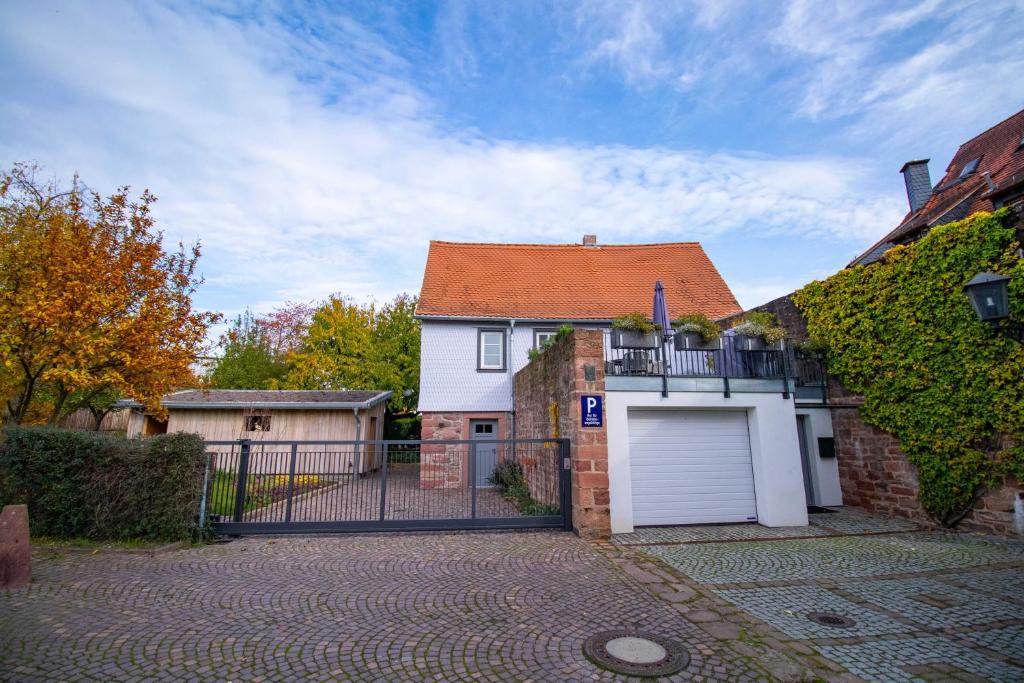 ein weißes Haus mit einem Tor und einer Garage in der Unterkunft Adlerlodge - Ferienhaus in Michelstadt