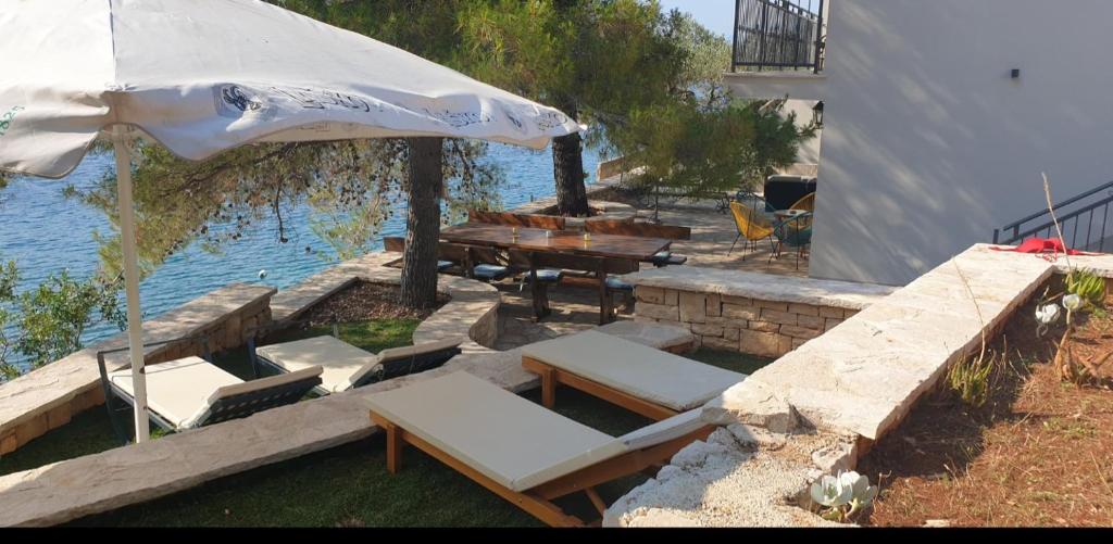 a patio with an umbrella and a table and chairs at Adriatic Queen in Gdinj