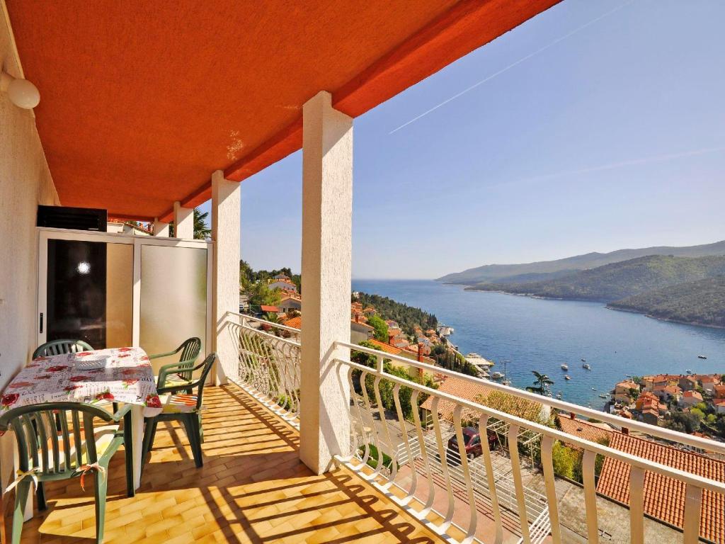 a balcony with a table and a view of the water at Apartments Paliska in Rabac