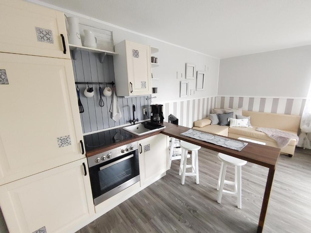 een keuken met witte kasten en een tafel en stoelen bij Ferienwohnung *Fenja* in Norddorf