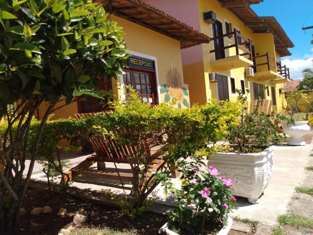 a bench in front of a building with plants at Pousada Dos Girassois Prado in Prado