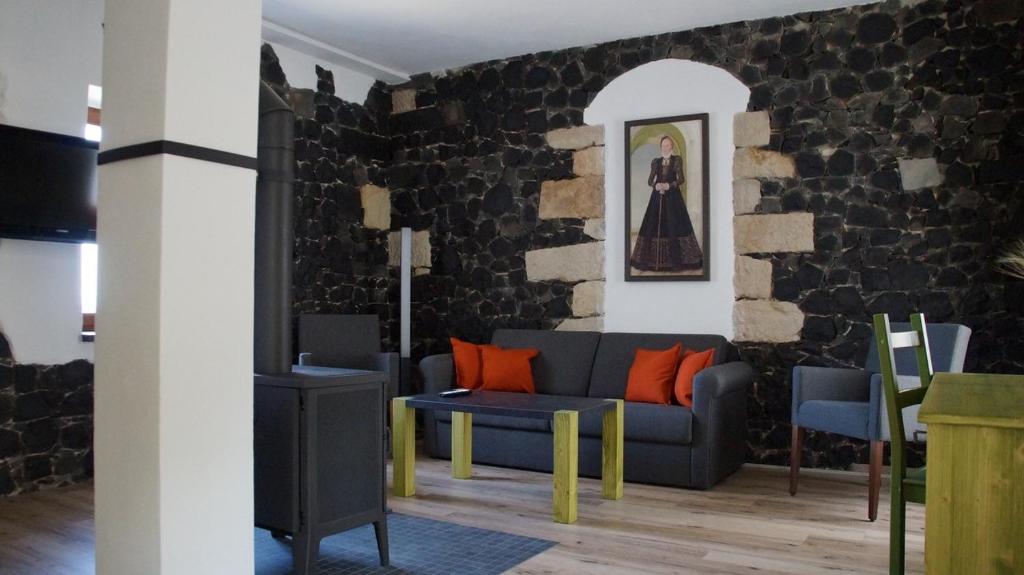 salon z niebieską kanapą i ceglaną ścianą w obiekcie Ferienhaus Mutter Anna's Refugium w mieście Stolpen