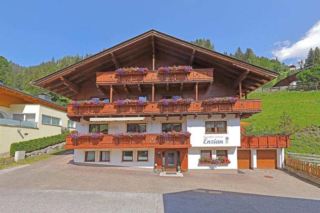a building with flower boxes on top of it at Gästehaus Enzian in Grossarl