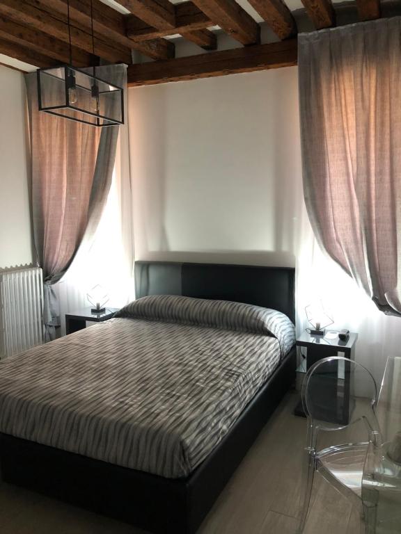 sypialnia z łóżkiem i 2 oknami w obiekcie Marin Traghetto - Locazione Turistica w Wenecji