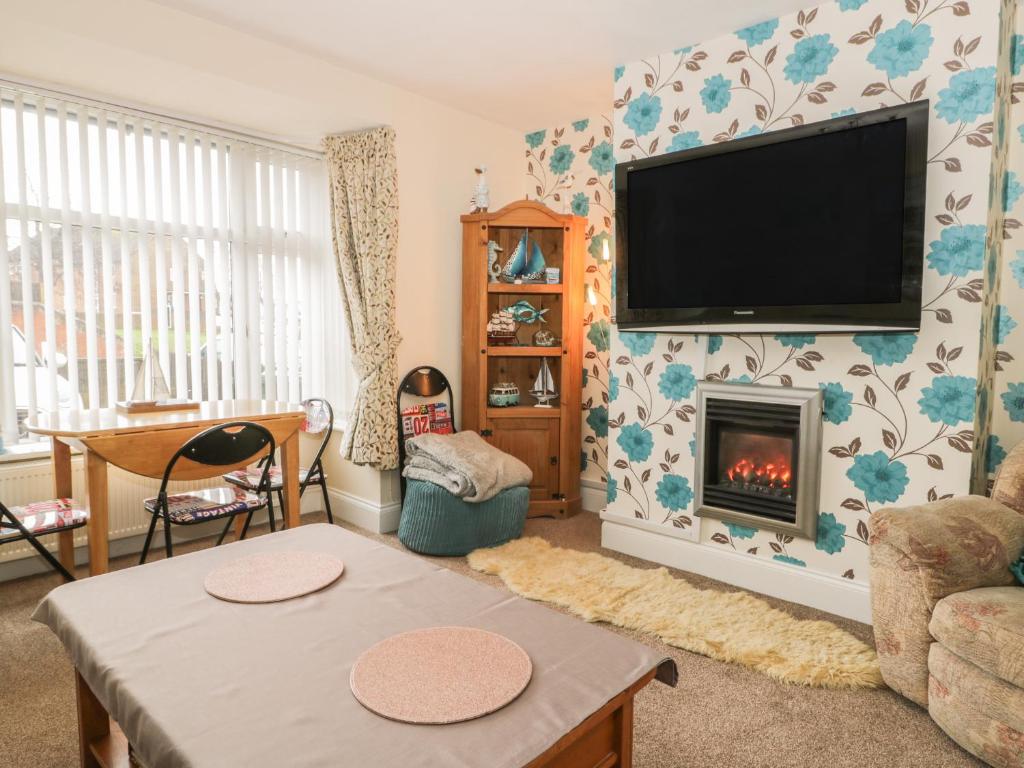 a living room with a tv and a fireplace at Helredale Retreat Whitby in Whitby