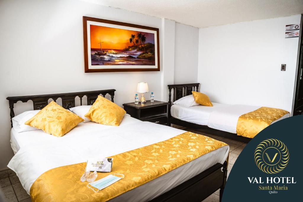 a hotel room with two beds with yellow pillows at Val Hotel Santamaria Quito in Quito