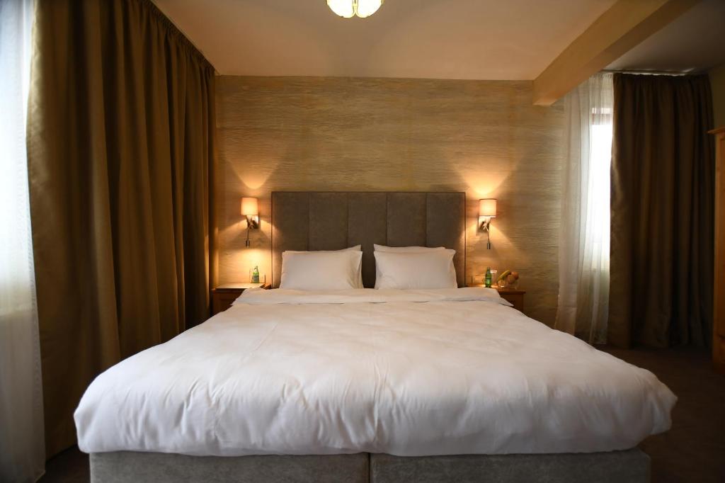 Un pat sau paturi într-o cameră la Club Dolomiti Hotel&Villa