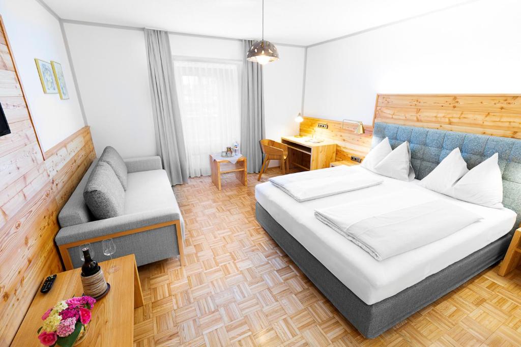 1 dormitorio con 1 cama, 1 sofá y 1 silla en Hotel-Restaurant-Café Krainer en Langenwang