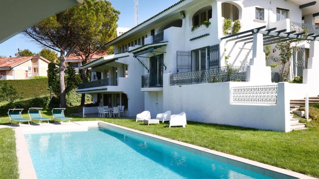a villa with a swimming pool in front of a house at Villa Sarah 102 Emma Villas in Riccione