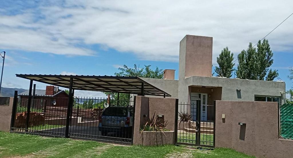 a house with a gate and a fence at Casa Miradores del Lago in Bialet Massé