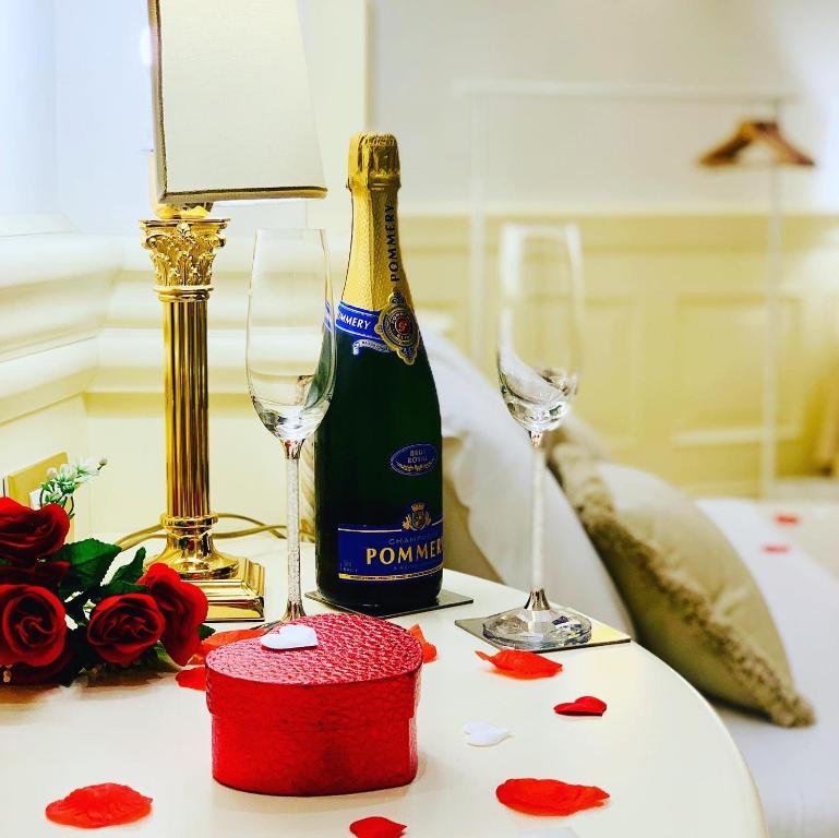 uma garrafa de champanhe e dois copos numa mesa em Simon's Guest House Rome em Roma