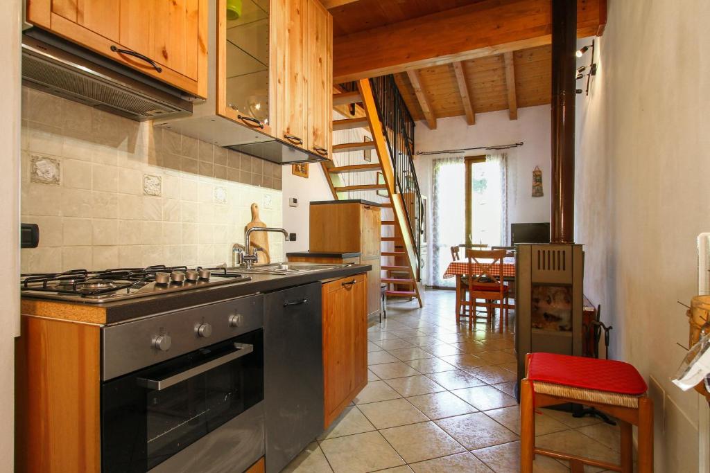 een keuken met een fornuis en een eetkamer bij 2 bedrooms apartement with furnished balcony at Riolunato 4 km away from the slopes in Riolunato