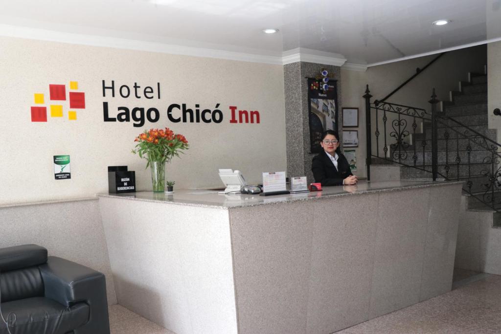 a man is sitting at a hotel laoco choco mi counter at Hoteles Bogotá Inn Lago Chico in Bogotá