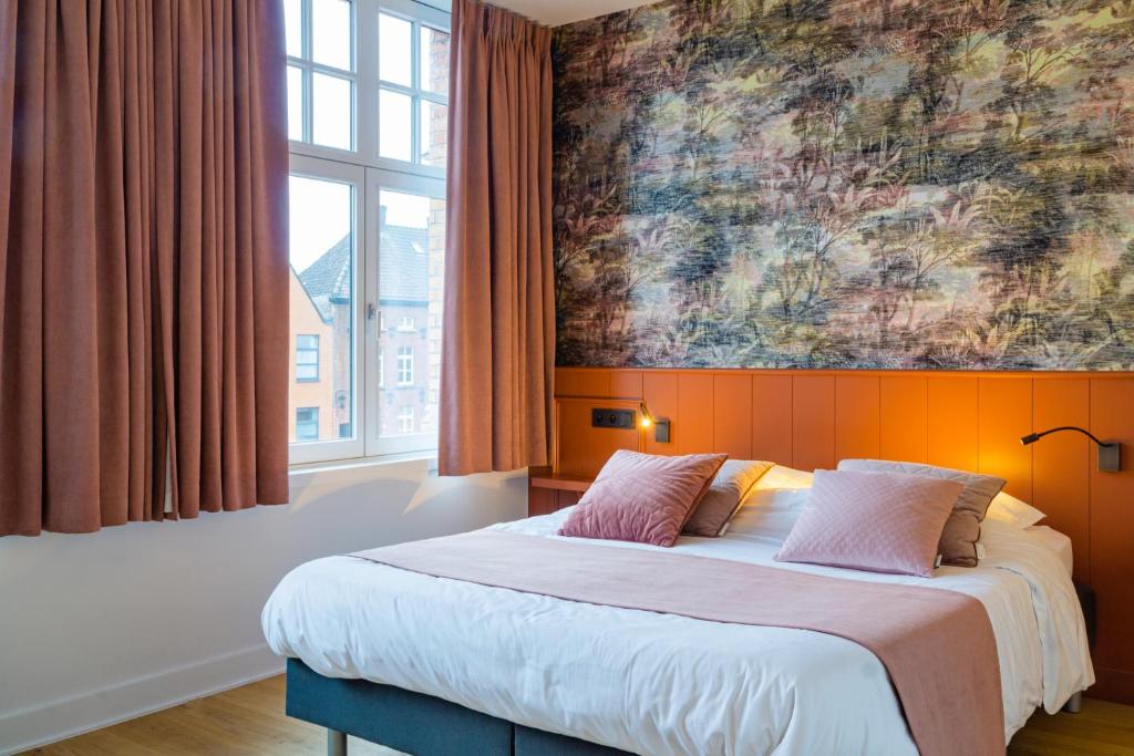 a bedroom with a bed with a large painting on the wall at B&B Contrast in Bruges