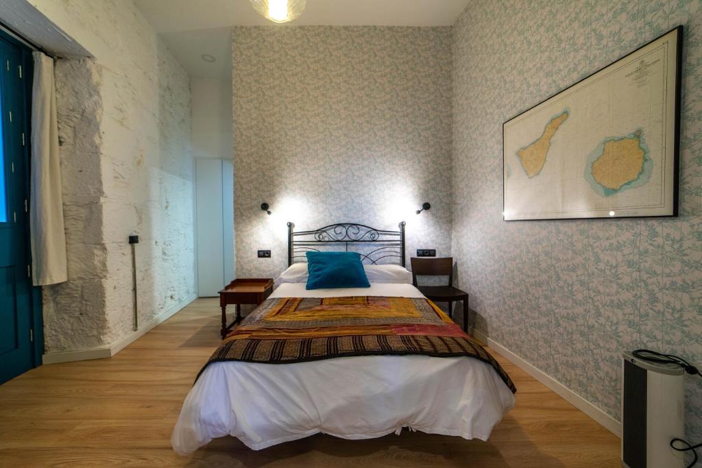 ein Schlafzimmer mit einem Bett und einem Bild an der Wand in der Unterkunft Eco-Aparment Vegueta in Las Palmas de Gran Canaria