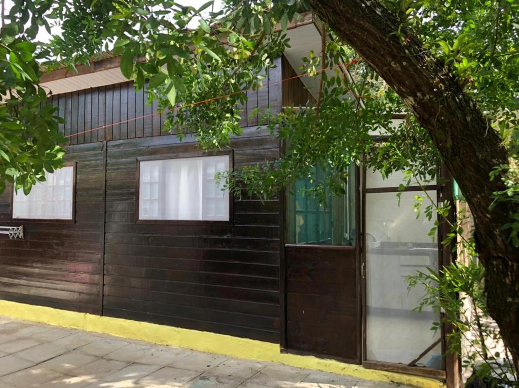 蜂蜜島的住宿－Casa Ilha do Mel，黑色的建筑,有门和树