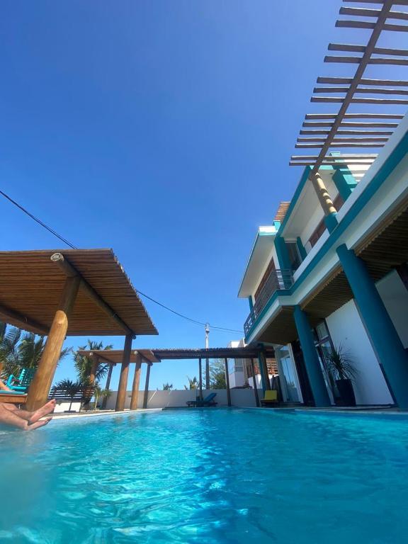 a villa with a swimming pool next to a building at MelBliss Gostoso in São Miguel do Gostoso
