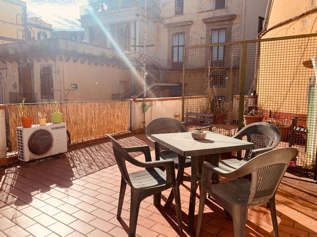 un patio con tavolo e sedie sul balcone. di Casetta nel cuore di Napoli con Terrazzo a Napoli
