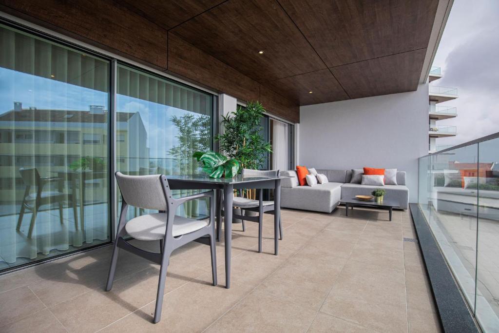 un soggiorno con tavolo, sedie e divano di Modern & Charming Apartment W/Pool by LovelyStay ad Algés