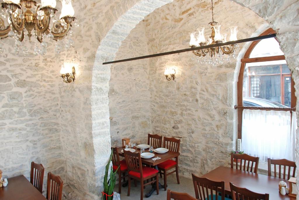 a dining room with a table and a stone wall at Muhsin Bey Konağı in Safranbolu