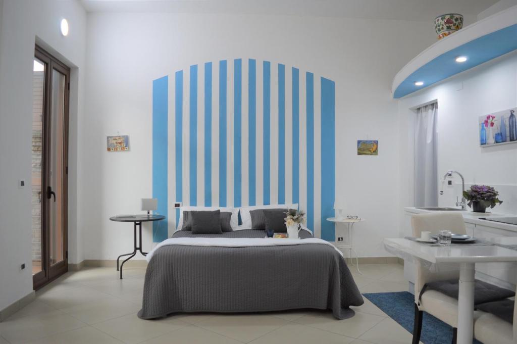 um quarto com uma cama e uma parede azul e branca em Palazzo Persephone em Locri