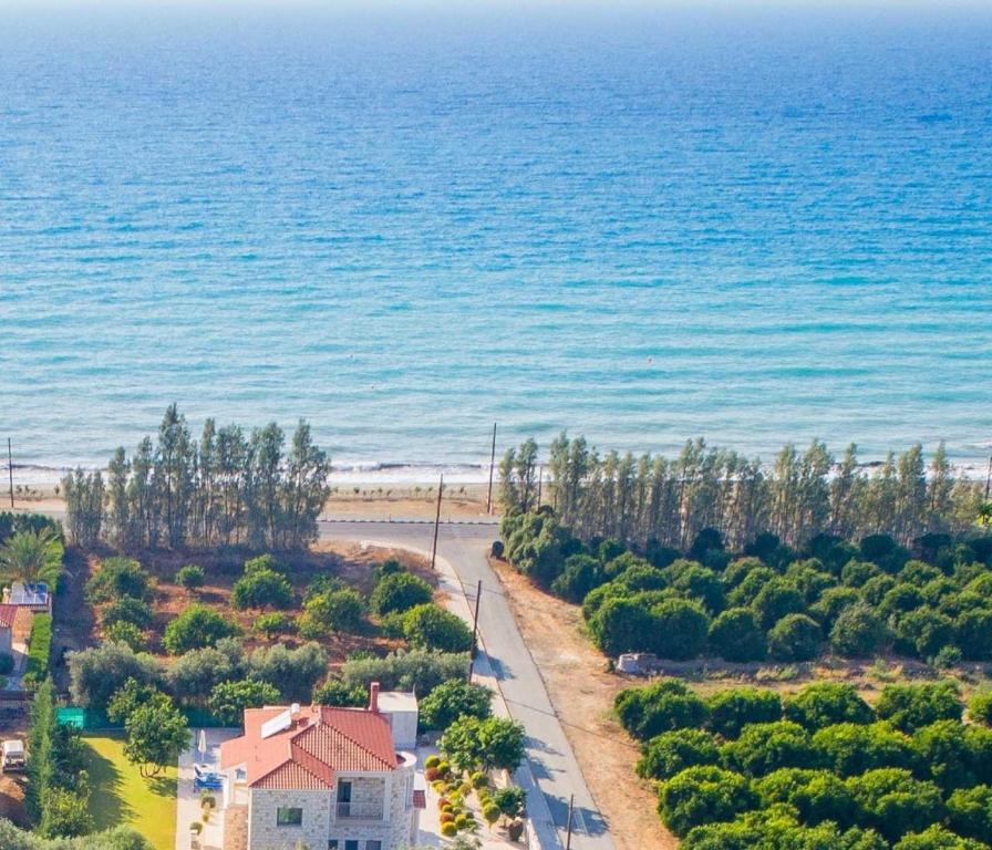 - une vue aérienne sur une maison et la plage dans l'établissement Rafaella Beach Villa- Pvt Pool-Near Sea/Beach, à Argaka