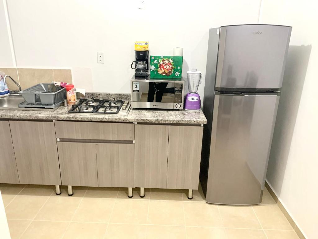 a kitchen with a stainless steel refrigerator and a counter at Hogar Cálido y Acogedor in León