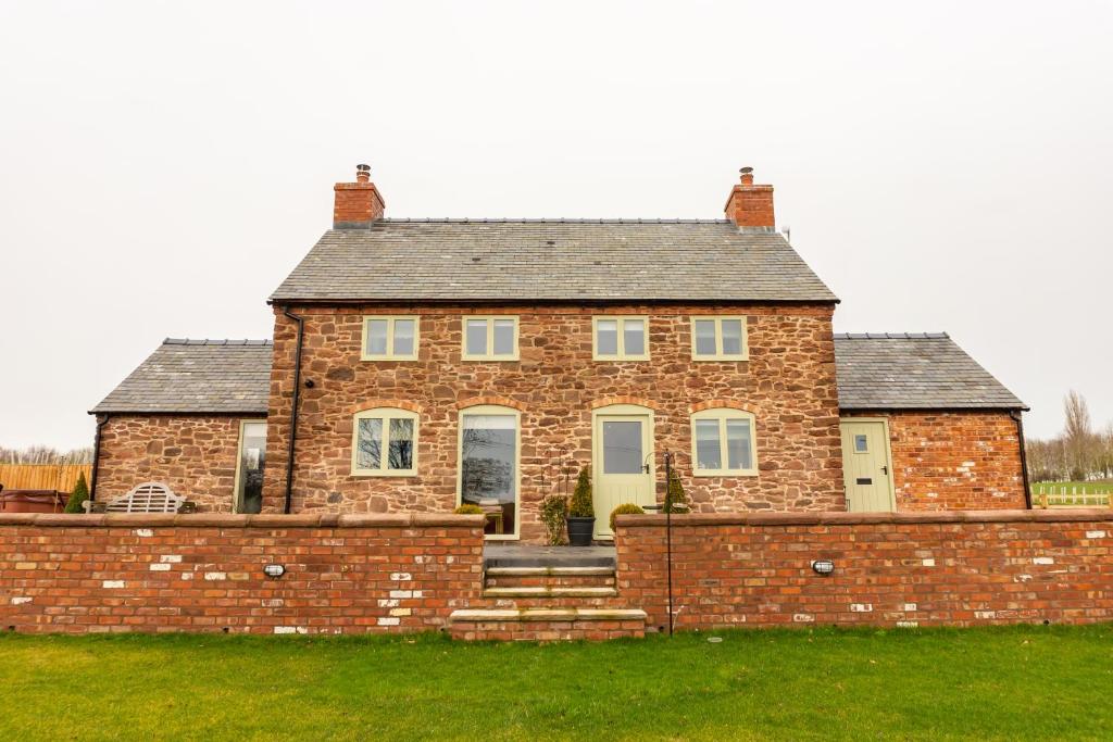 an old brick house with a brick wall at The Patches in Shrewsbury