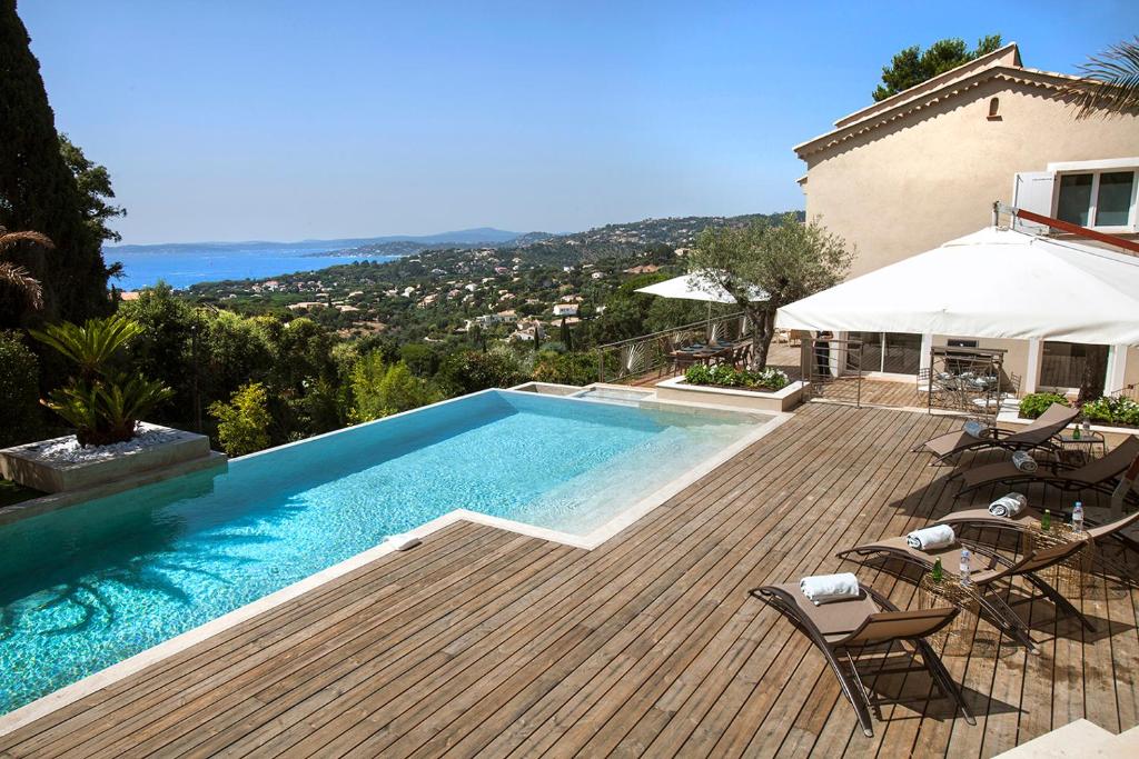 - une piscine sur une terrasse en bois à côté d'une maison dans l'établissement Prestigious sea view villa, à La Garonnette-Plage