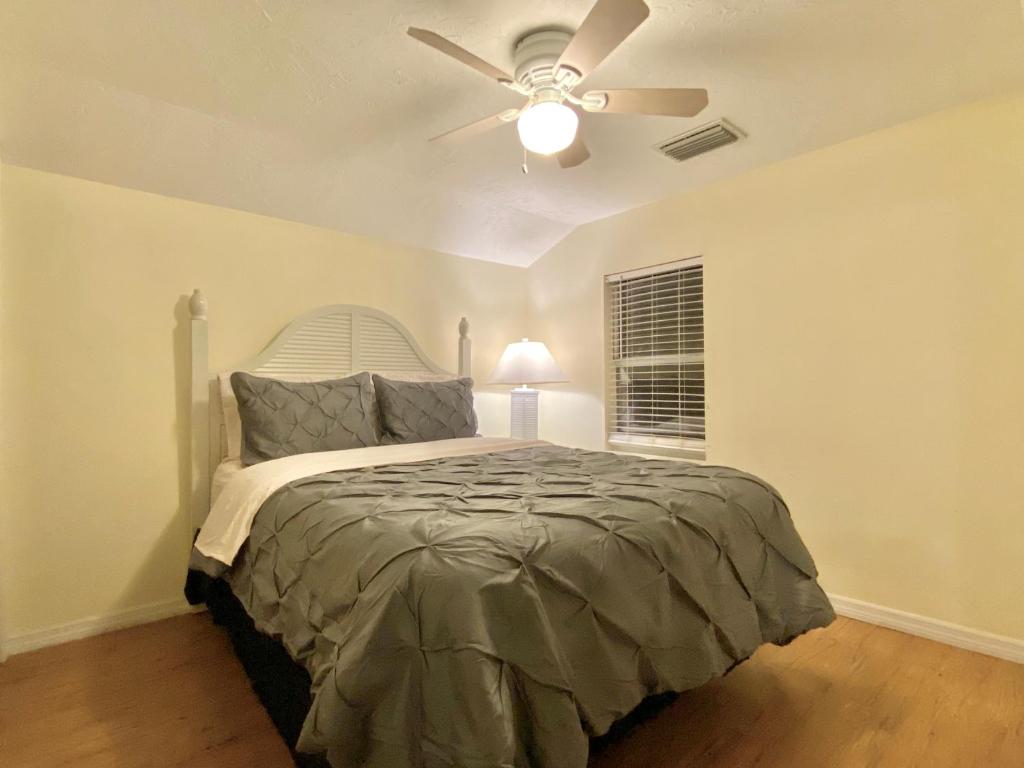 a bedroom with a bed with a ceiling fan at Siesta Beach Cottage, Sleeps 6, Walk to Beach, Stores, & Restaurants in Siesta Key