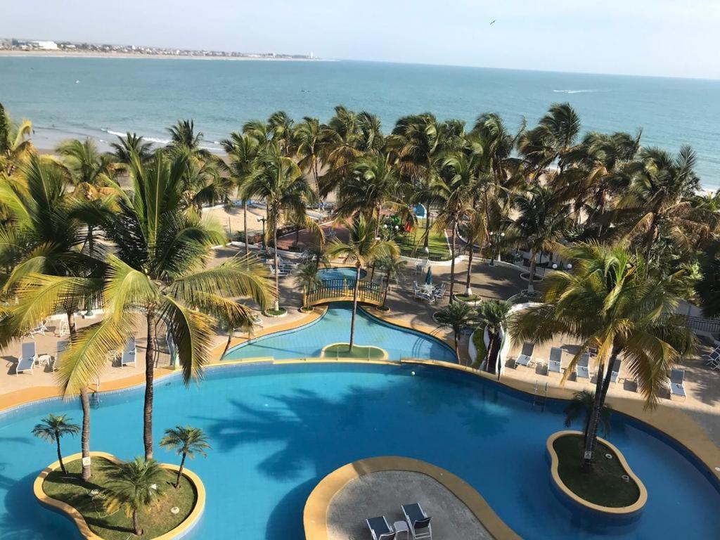 ein Luftblick auf ein Resort mit einem Pool und Palmen in der Unterkunft Departamento Carabelas de Colón in Playas