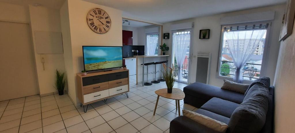un salon avec un canapé et une télévision dans l'établissement T3 entièrement rénové - 5 couchages, à Lourdes